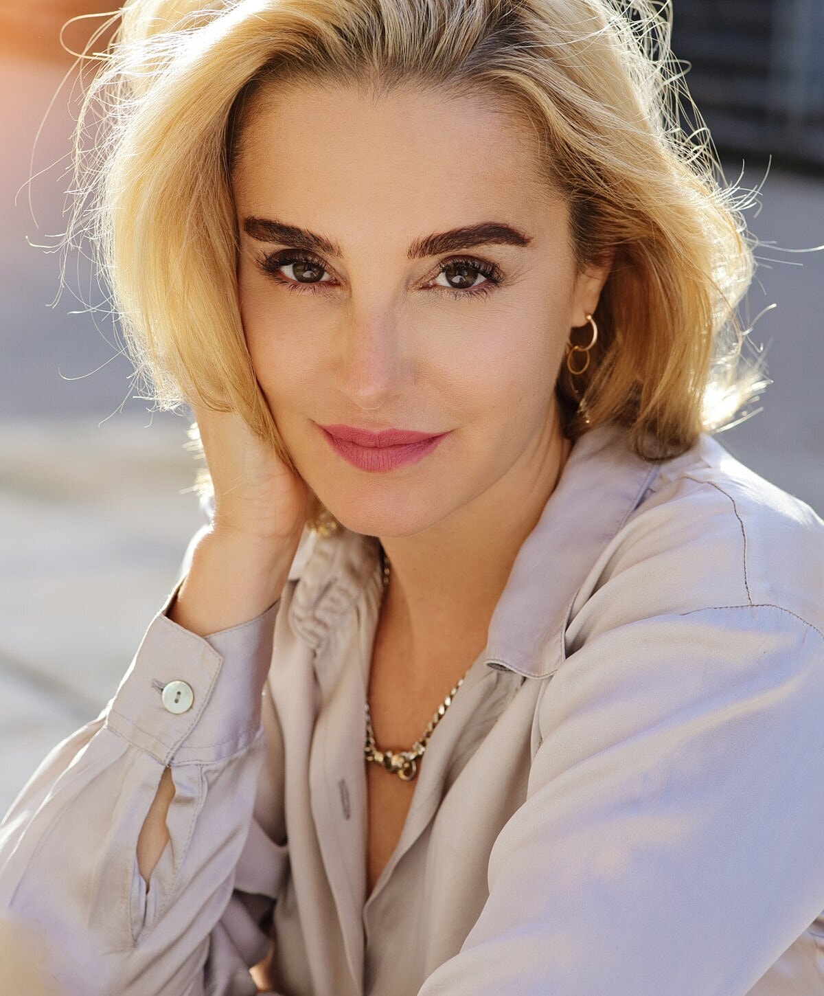 Smiling woman in elegant blouse, natural lighting.
