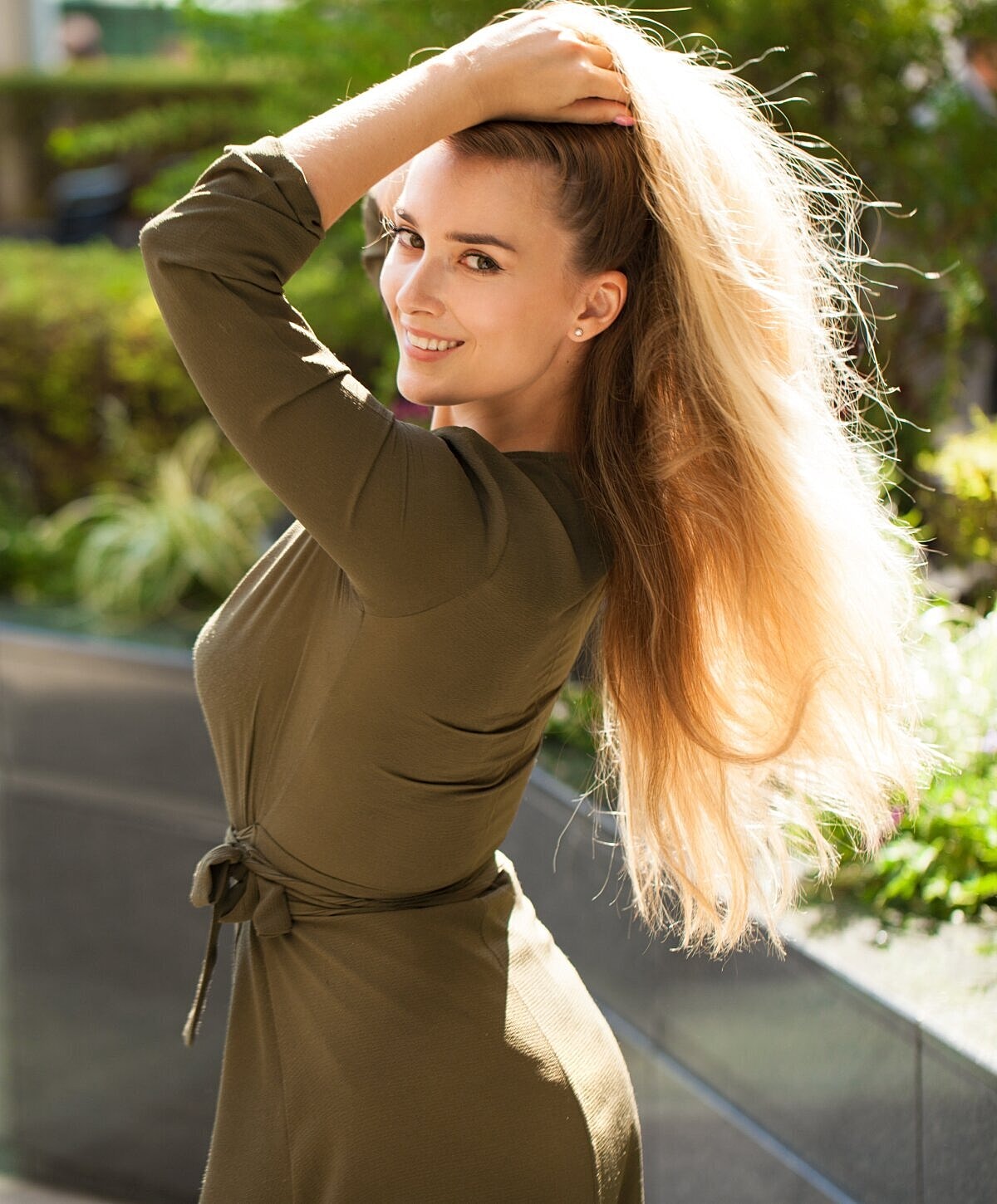 Smiling woman posing outdoors with long hair.